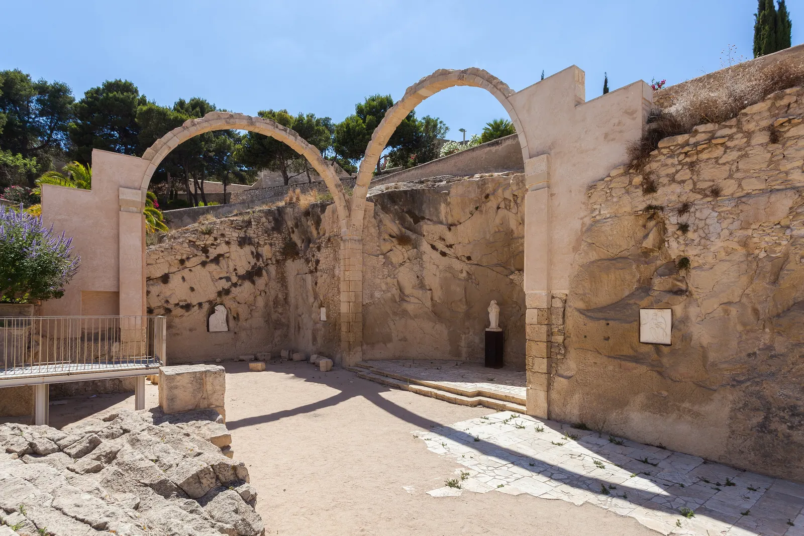 Two stone arches among the ruins inside Santa Bárbara Castle, Alicante; a general photograph of the castle above the quarter